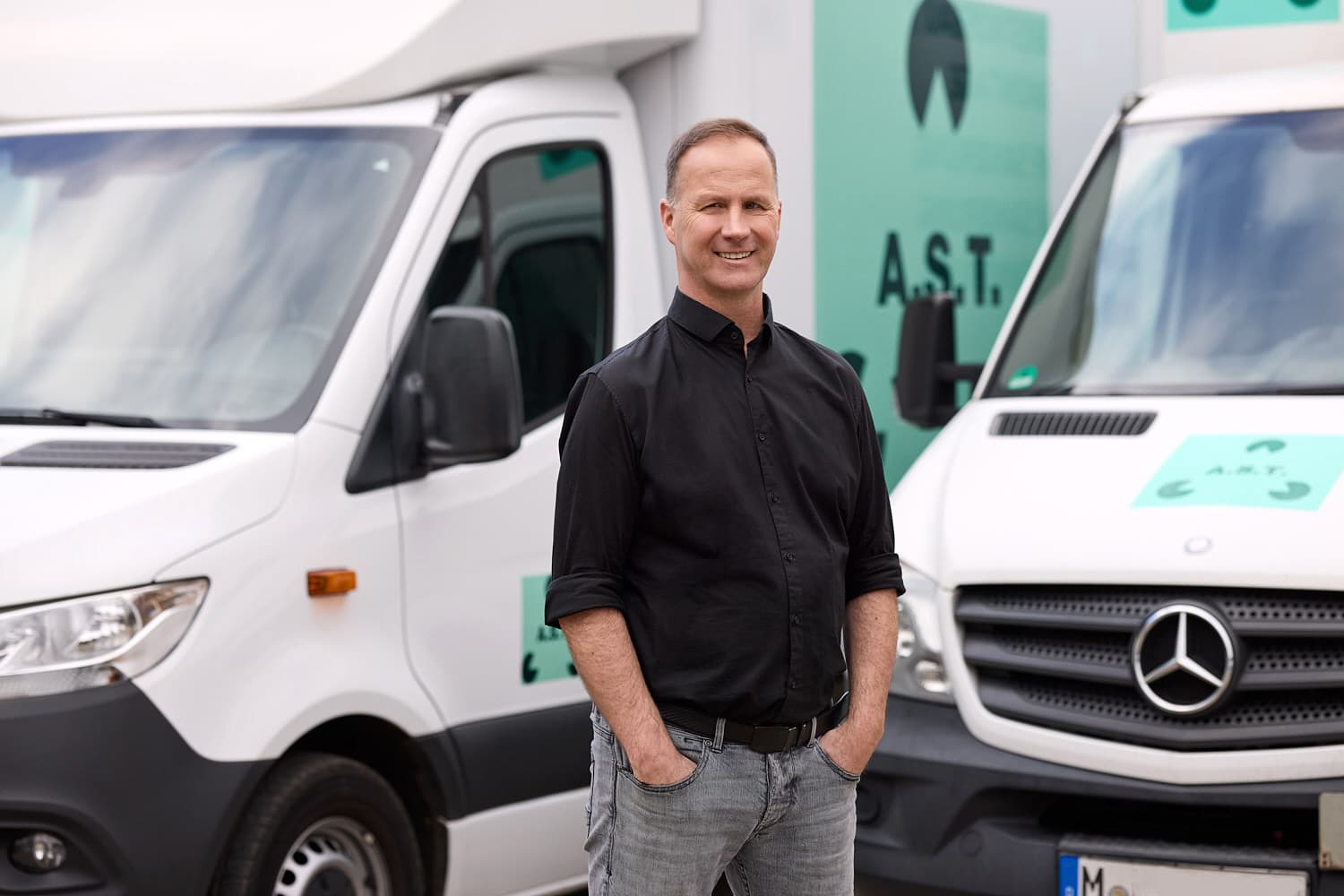 Alexander Stenzenberger von A.S.T. Alexander Stenzenberger Asbestrückbau vor seinen Fahrzeugen